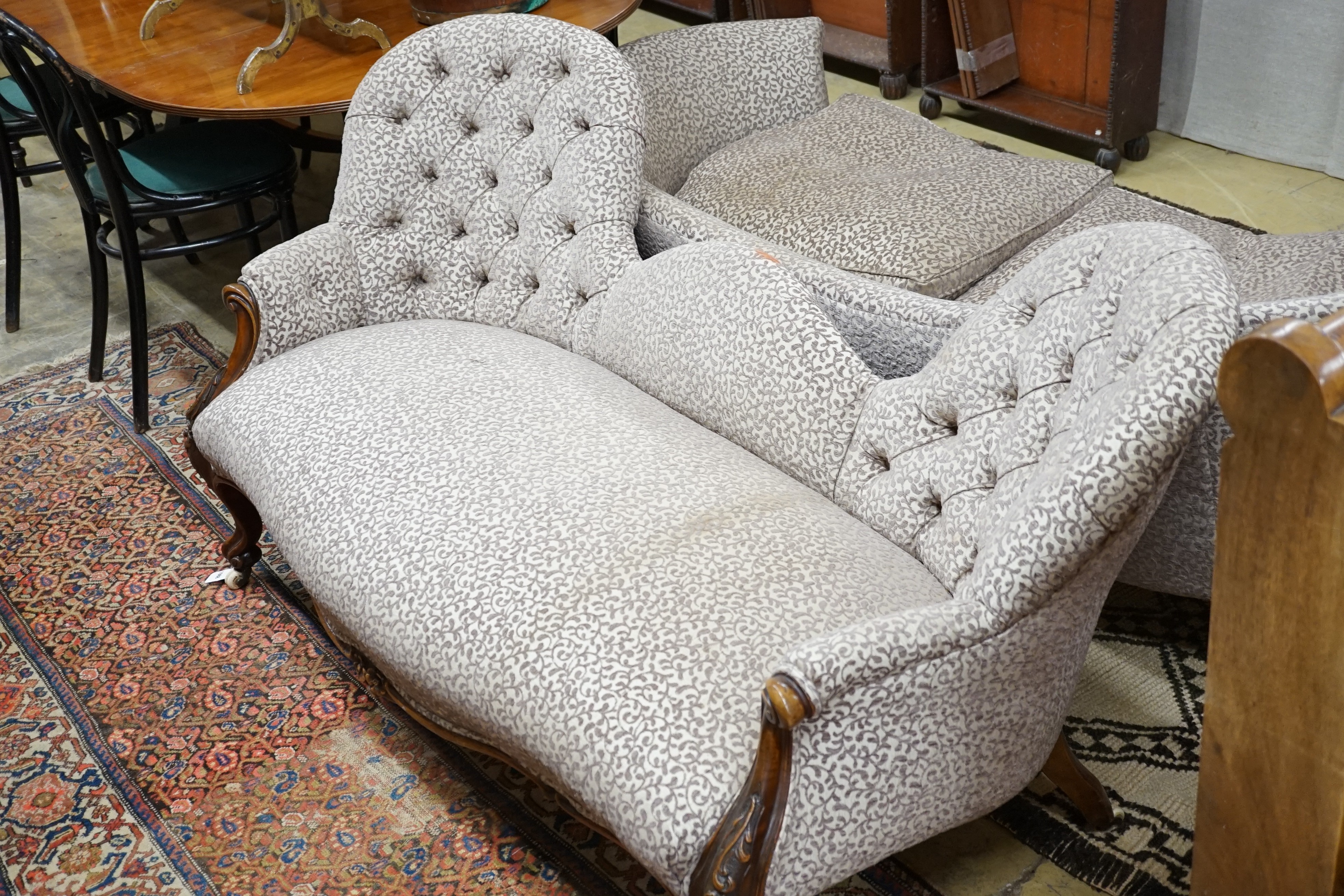 A Victorian and later walnut button back upholstered salon settee, with cabriole legs fitted ceramic castors, length 174cm
